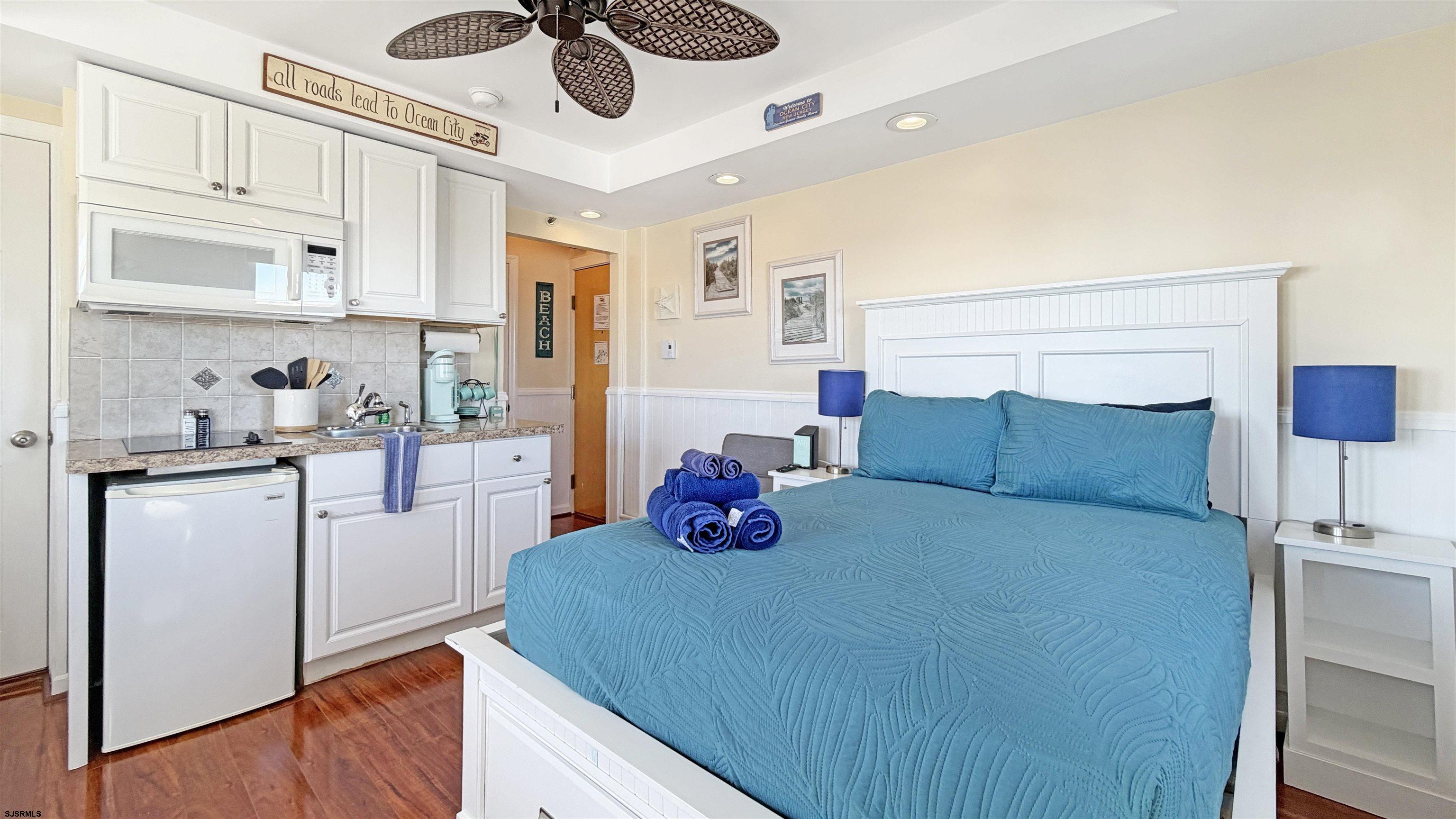 807 East 8th Street, Unit 511 Ocean City, NJ 08226 - Photo 4 of 12 a kitchen with stainless steel appliances kitchen island granite countertop a table chairs in it and wooden floors
