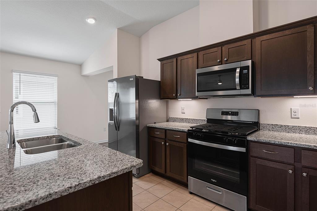 20 Willow Place Palm Coast, FL 32164 - Photo 15 of 61 a kitchen with granite countertop stainless steel appliances and wooden cabinets