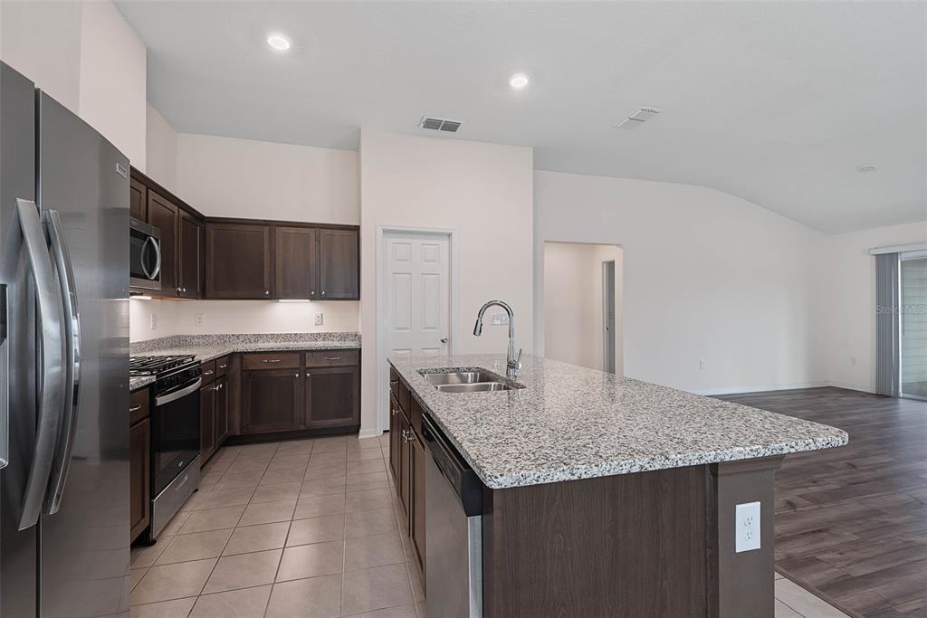 20 Willow Place Palm Coast, FL 32164 - Photo 18 of 61 a kitchen with stainless steel appliances granite countertop a sink stove and refrigerator