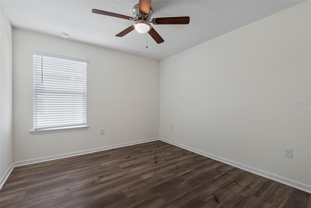 20 Willow Place Palm Coast, FL 32164 - Photo 30 of 61 an empty room with wooden floor ceiling fan and windows