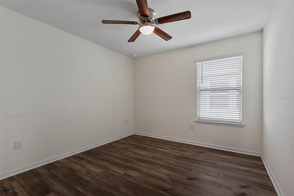20 Willow Place Palm Coast, FL 32164 - Photo 32 of 61 an empty room with wooden floor ceiling fan and windows