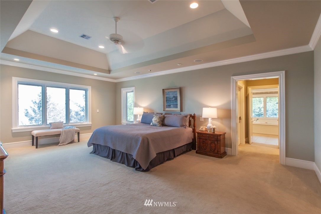 1334 Chuckanut Crest Drive Bellingham, WA 98229 - Photo 27 of 40 a spacious bedroom with a large bed and a chandelier