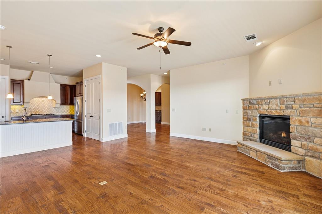610 Via Ravello, Unit 410 Irving, TX 75039 - Photo 6 of 28 a view of an empty room and kitchen with fireplace ceiling fan