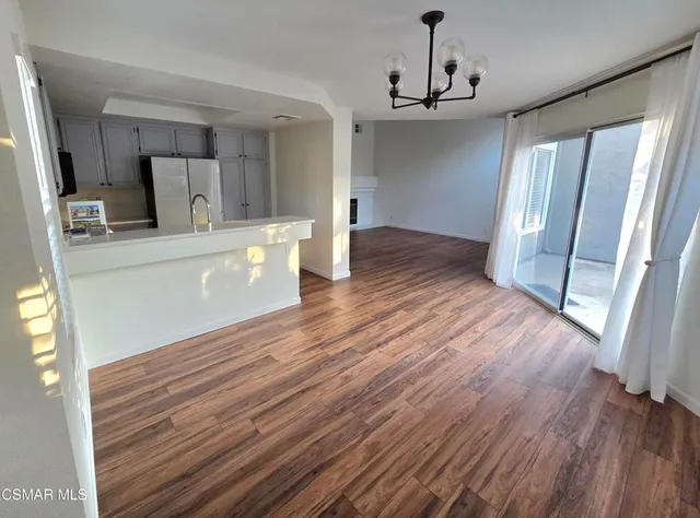 a view of a kitchen with wooden floor and window