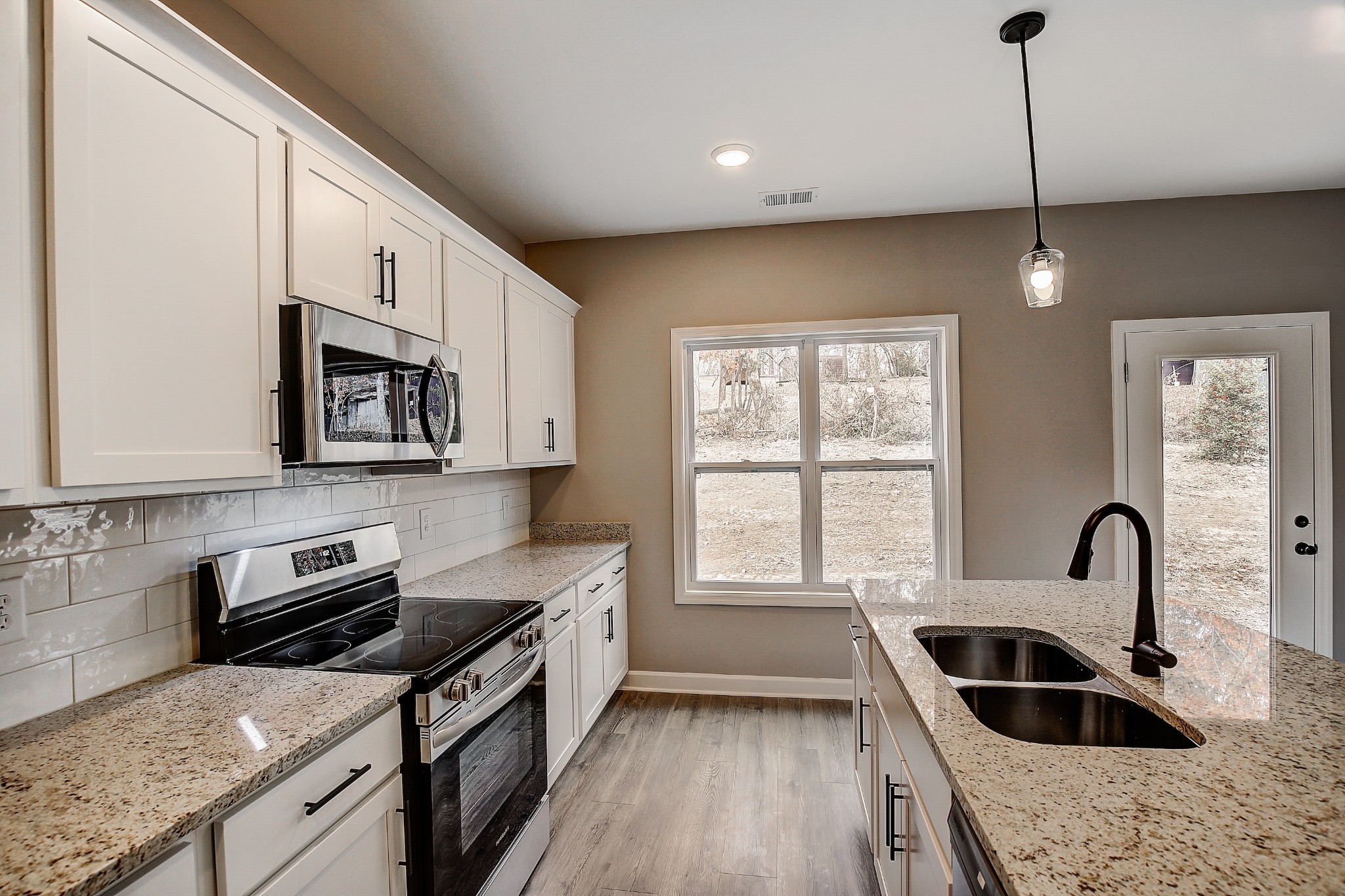 1770 Fenway Loop Antioch, TN 37013 - Photo 13 of 32 a kitchen with granite countertop a stove a sink and a microwave