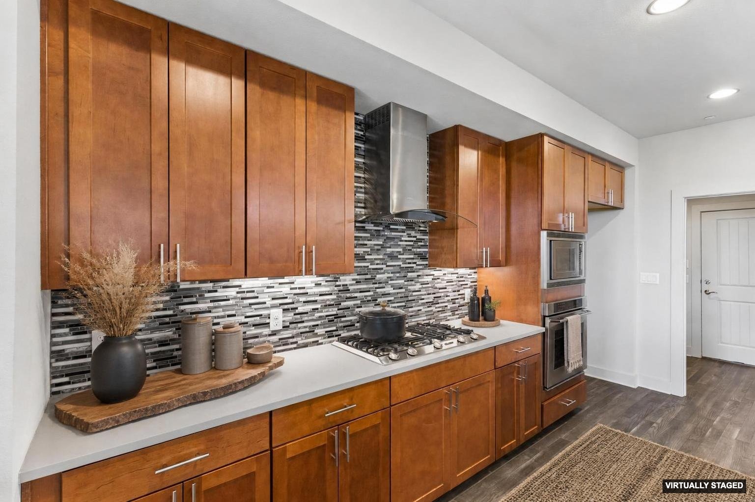 8110 Ranch Road 2222, Unit 68 Austin, TX 78730 - Photo 4 of 24 A contemporary kitchen features rich wood cabinetry, stainless steel appliances, and sleek tile backsplash.
