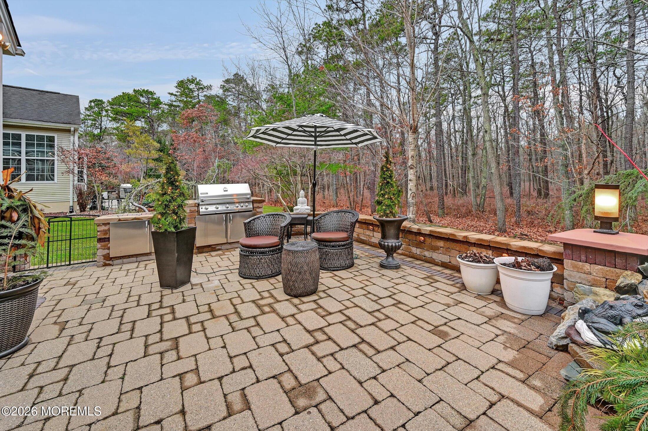 38 Park Ridge Way Jackson, NJ 08527 - Photo 5 of 22 a view of a patio with table and chairs potted plants and a large tree