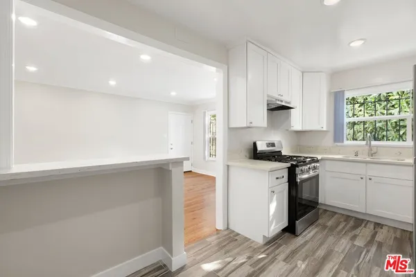 a kitchen with granite countertop white cabinets and white appliances