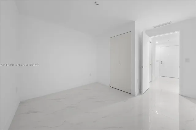 an empty room with windows and closet
