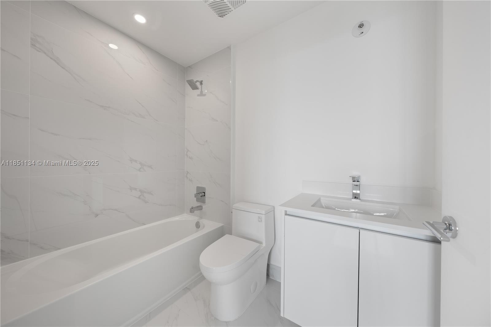 700 Northeast 24th Street, Unit 2503 Miami, FL 33137 - Photo 33 of 61 a bathroom with a granite countertop sink a toilet and bathtub