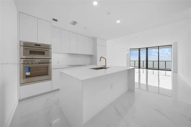 a kitchen with granite countertop a refrigerator and a stove top oven