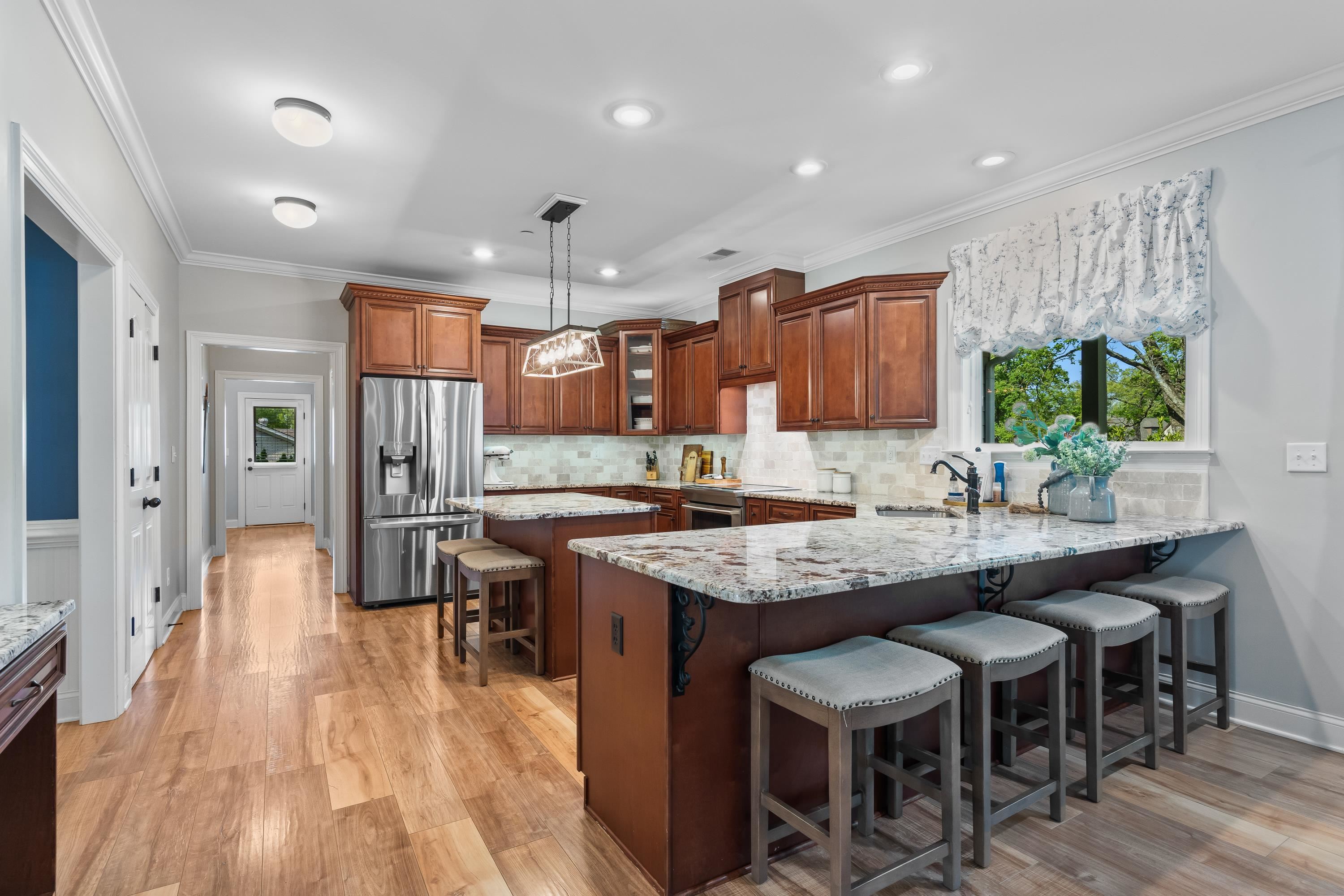 210 Poplar Acres Road Piperton, TN 38017 - Photo 12 of 40 a kitchen with stainless steel appliances granite countertop a table chairs sink and wooden floor