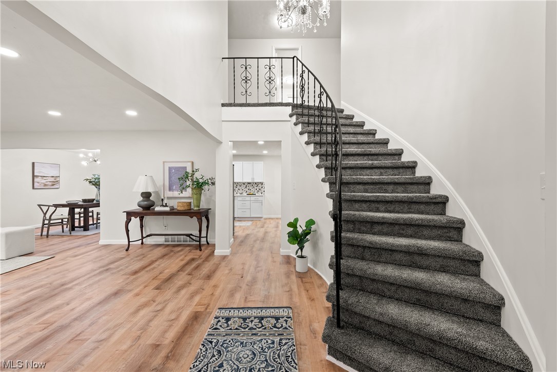 896 Beechers Brook Road Cleveland, OH 44143 - Photo 4 of 35 Stairs with light hardwood / wood-style floors, a high ceiling, and a chandelier