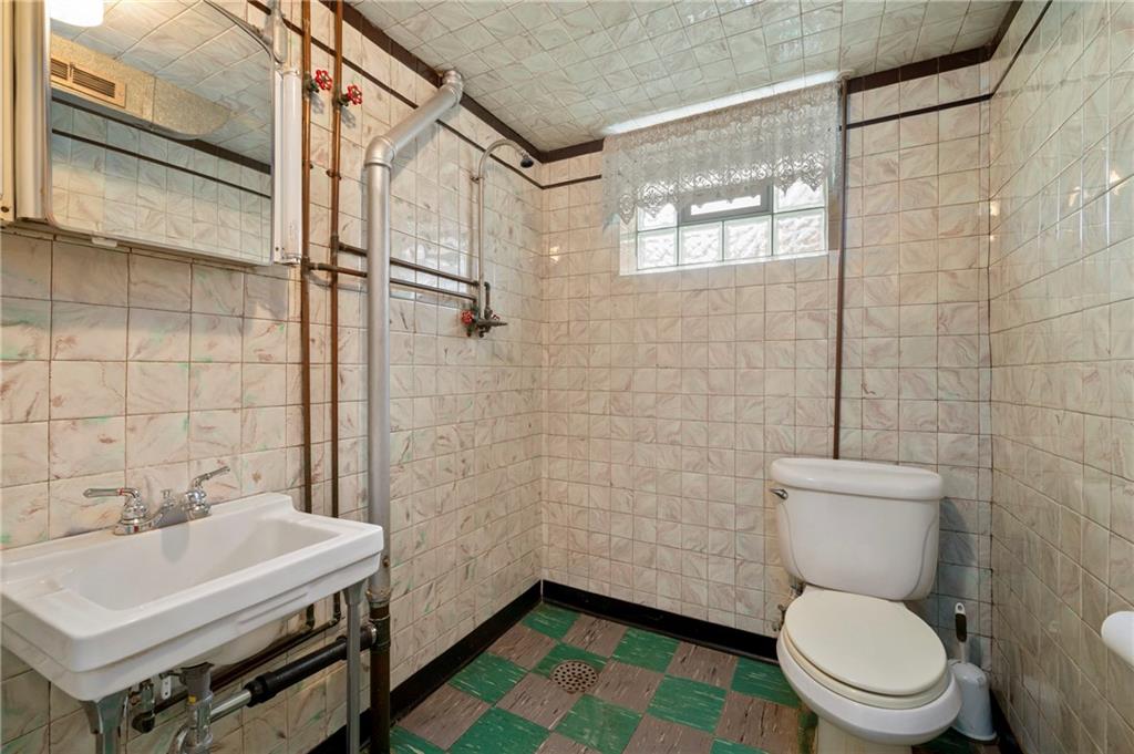 663 Loretta Street Pittsburgh, PA 15217 - Photo 17 of 17 a bathroom with a sink a toilet and a mirror