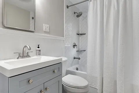 a bathroom with a sink a toilet and shower