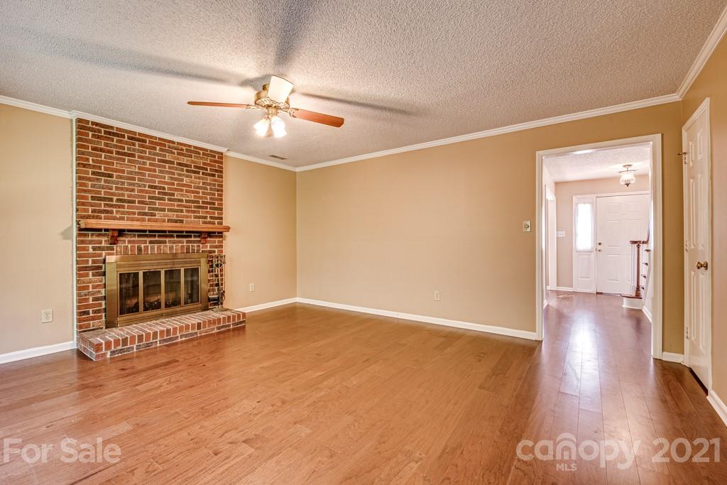 4516 Brownes Ferry Road Charlotte, NC 28269 - Photo 13 of 32 wooden floor in an empty room with a fireplace