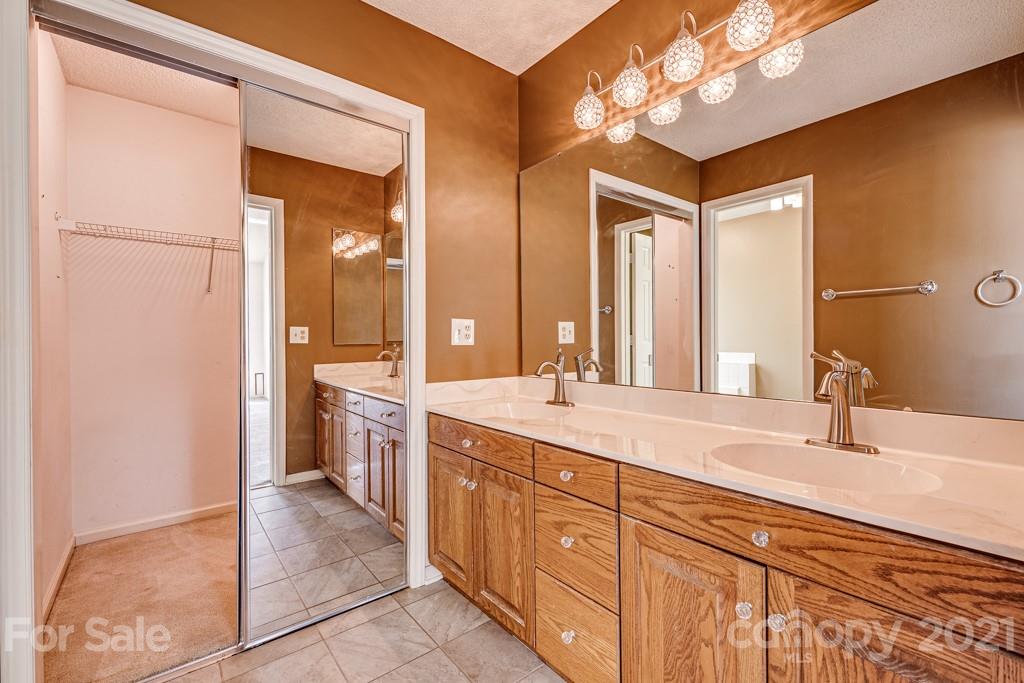 4516 Brownes Ferry Road Charlotte, NC 28269 - Photo 19 of 32 a spacious bathroom with a double vanity sink a large mirror and a shower