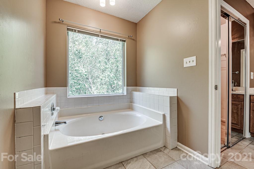 4516 Brownes Ferry Road Charlotte, NC 28269 - Photo 21 of 32 a white bath tub sitting next to a window