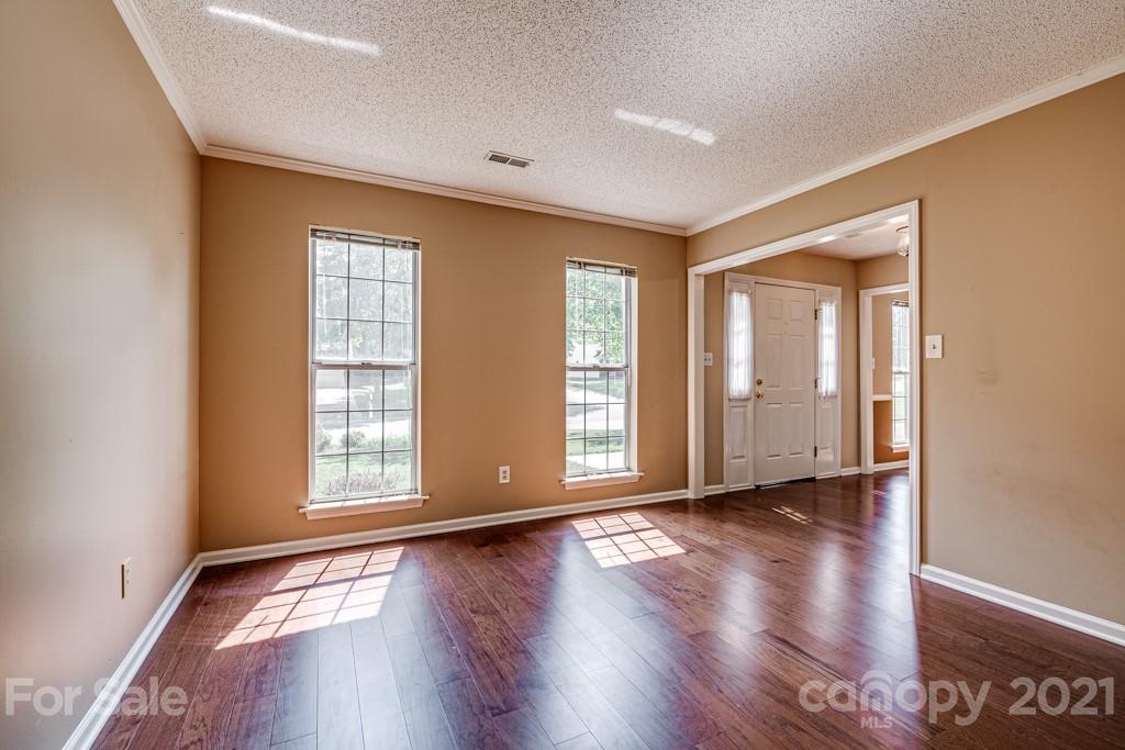 4516 Brownes Ferry Road Charlotte, NC 28269 - Photo 4 of 32 an empty room with wooden floor and windows