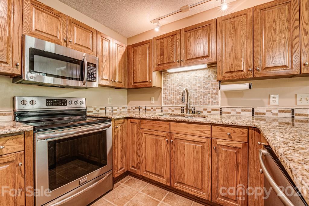 4516 Brownes Ferry Road Charlotte, NC 28269 - Photo 8 of 32 a kitchen with stainless steel appliances granite countertop a stove microwave and sink
