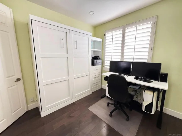a view of a workspace with furniture and a window