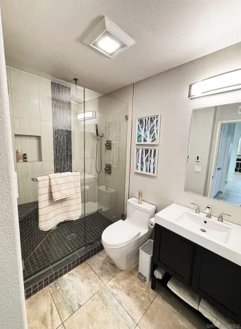 a bathroom with a double vanity sink toilet and shower