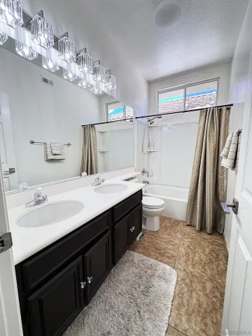 a bathroom with a double vanity sink mirror and toilet
