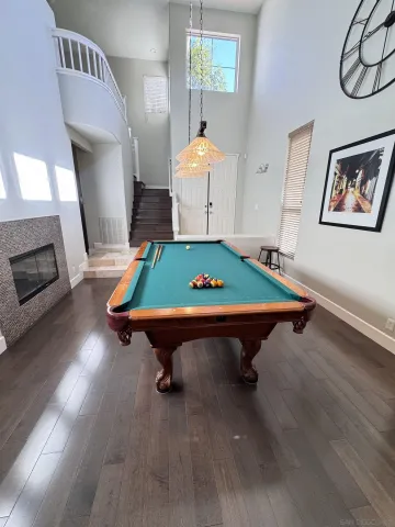 a room with pool table windows and wooden floor