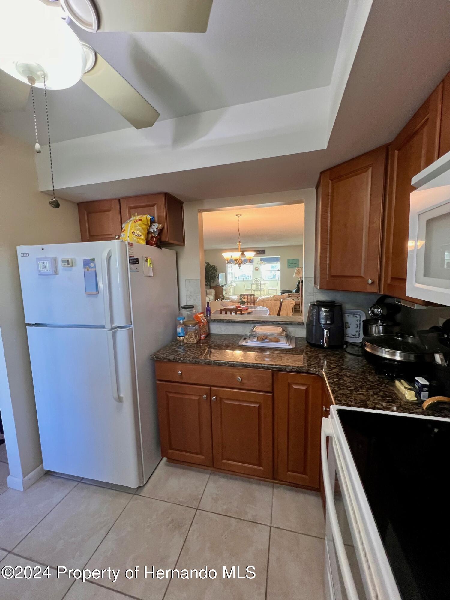 4660 Marine Parkway New Port Richey, FL 34652 - Photo 4 of 18 a kitchen with stainless steel appliances granite countertop a refrigerator a sink a stove and white cabinets