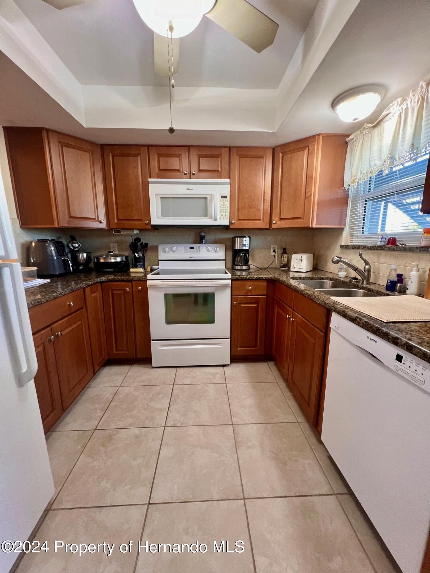 4660 Marine Parkway New Port Richey, FL 34652 - Photo 5 of 18 a kitchen with stainless steel appliances granite countertop a stove a sink and a microwave
