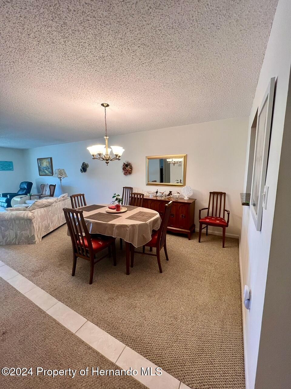 4660 Marine Parkway New Port Richey, FL 34652 - Photo 8 of 18 a living room with furniture a table and a chandelier