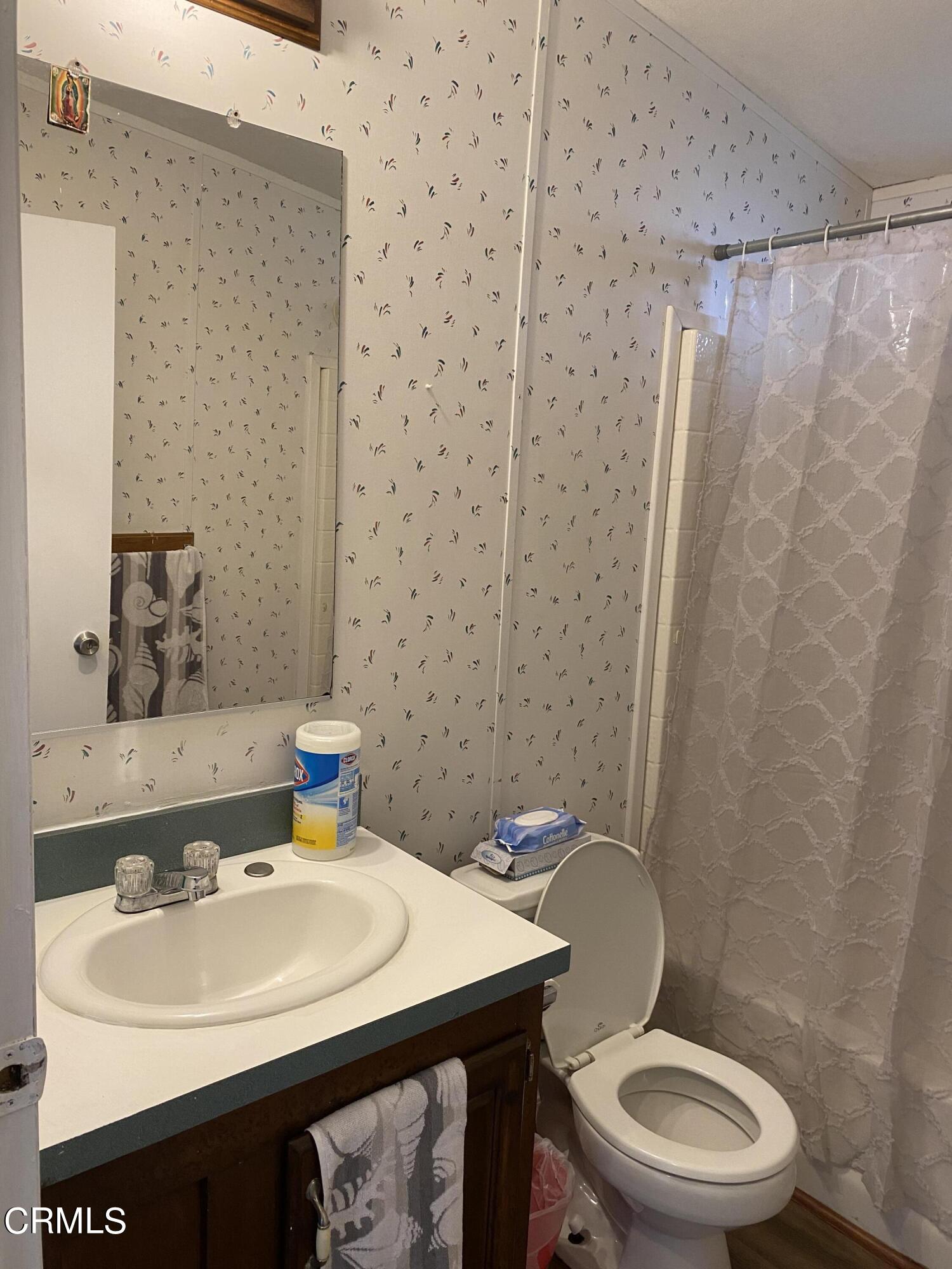 1853 Ives Avenue, Unit 151 Oxnard, CA 93033 - Photo 4 of 11 a bathroom with a sink a toilet and a mirror