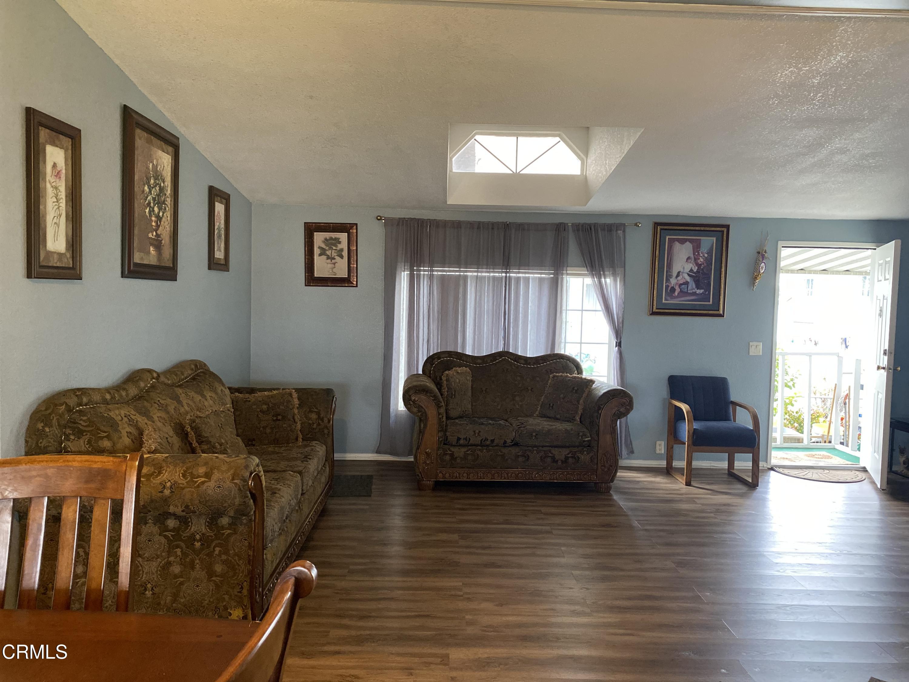 1853 Ives Avenue, Unit 151 Oxnard, CA 93033 - Photo 6 of 11 a living room with furniture and a wooden floor