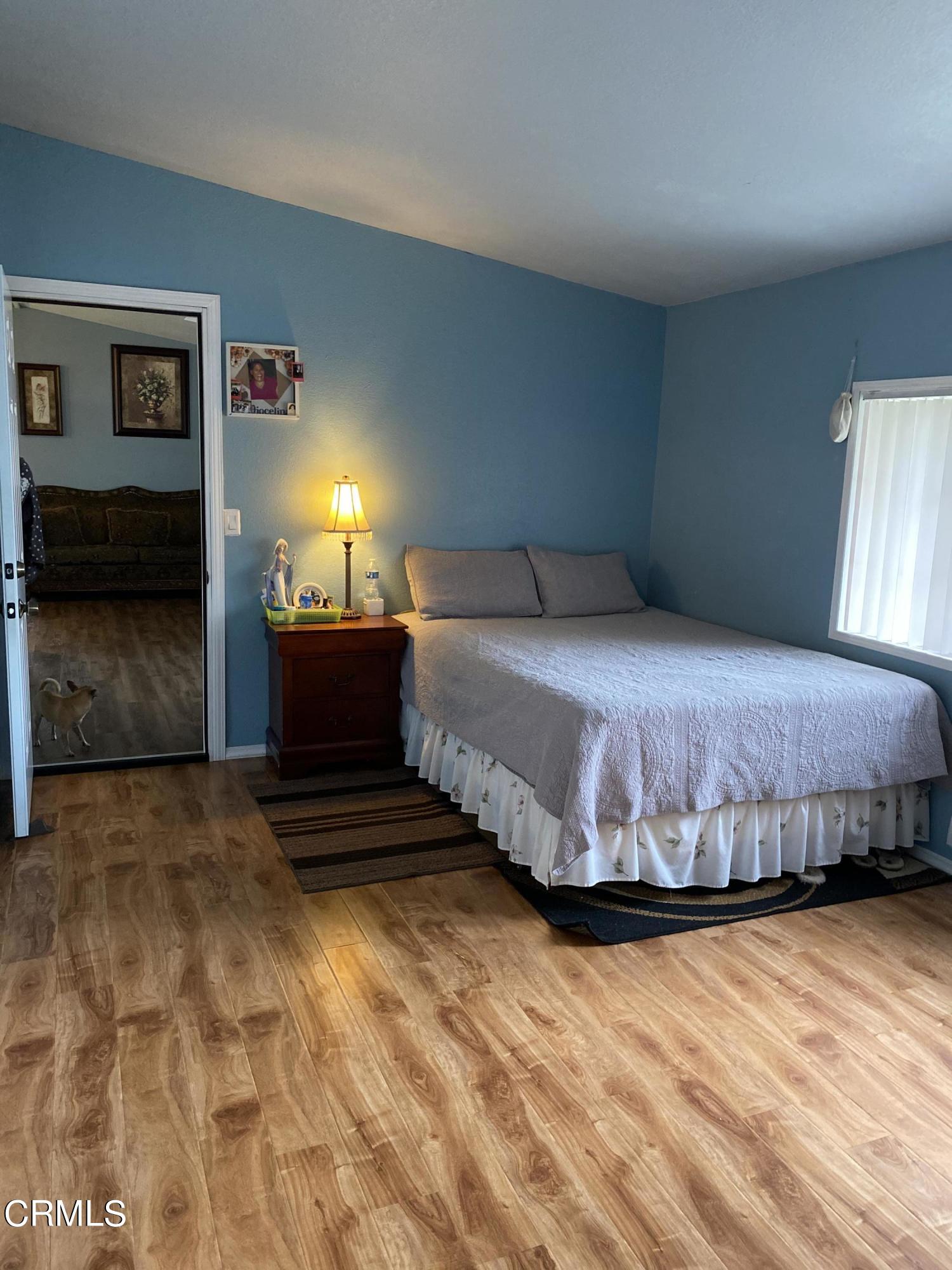 1853 Ives Avenue, Unit 151 Oxnard, CA 93033 - Photo 10 of 11 a bedroom with a bed and lamp with table