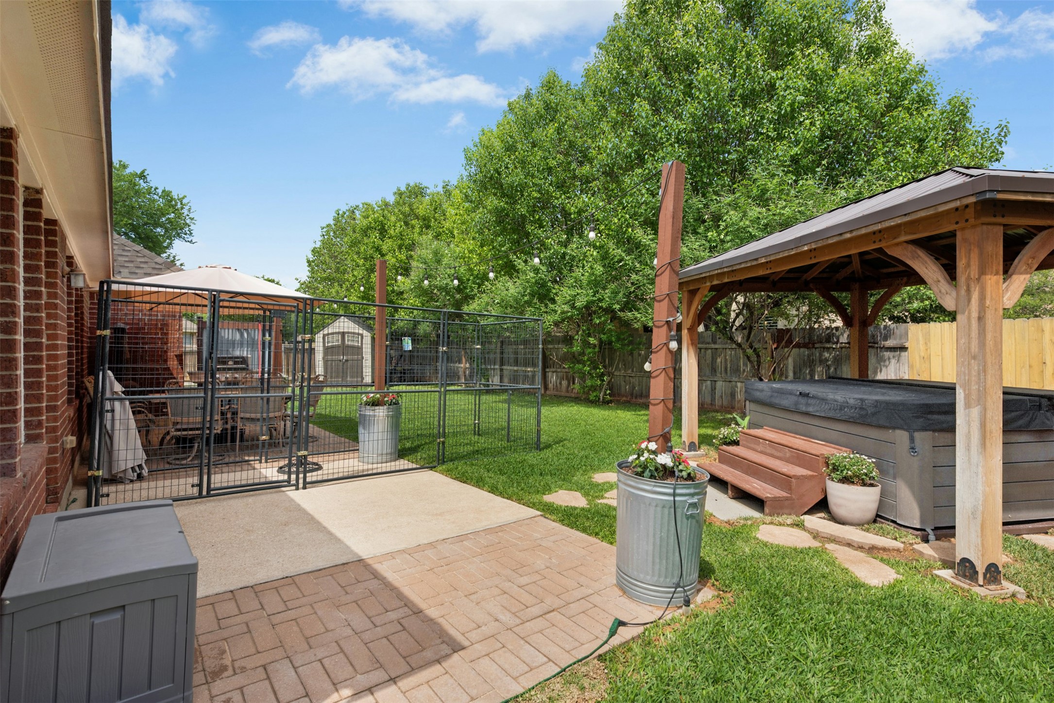 30013 Edgewood Drive Georgetown, TX 78628 - Photo 28 of 39 The property features a spacious backyard with a hot tub under a wooden gazebo, a paved patio area