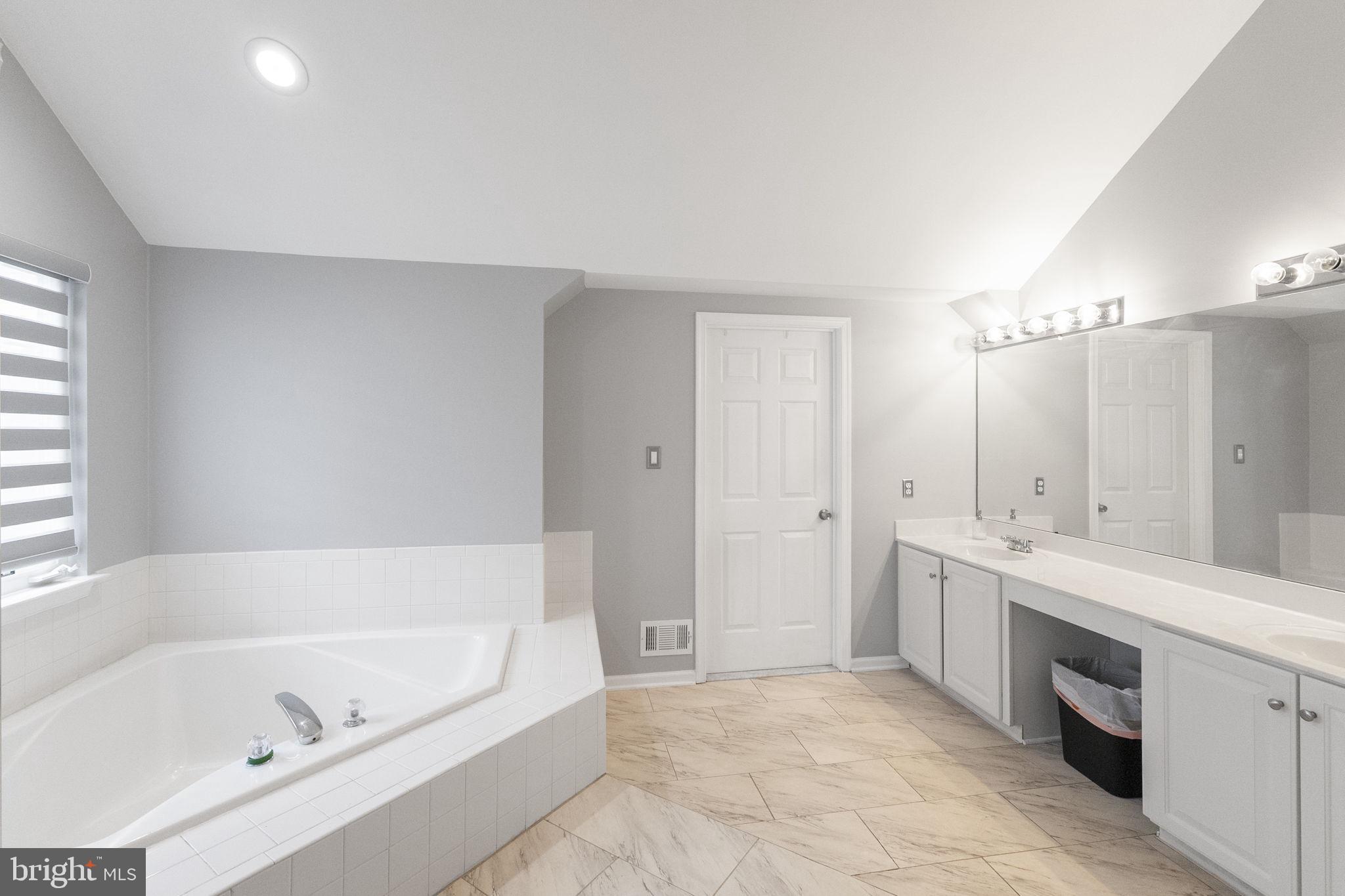 6455 Saddlebrook Lane Frederick, MD 21701 - Photo 22 of 38 a spacious bathroom with a bathtub sink and mirror