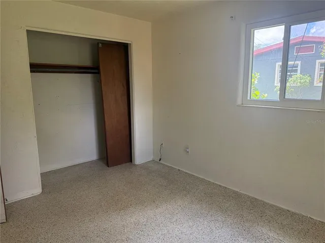 an empty room with windows and closet