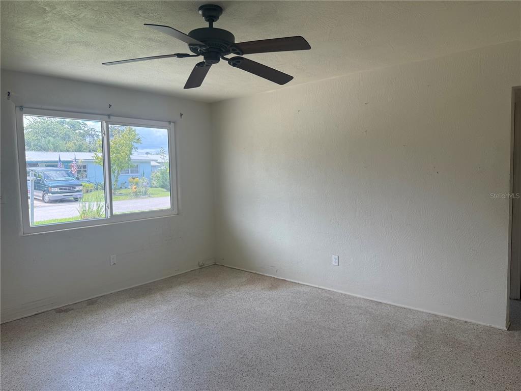 113 Neptune Drive Edgewater, FL 32132 - Photo 6 of 24 an empty room with a window and a fan