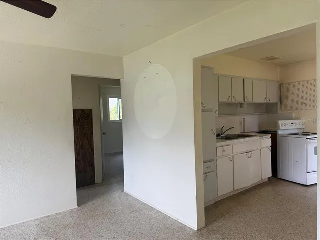 a kitchen with granite countertop white cabinets and white appliances