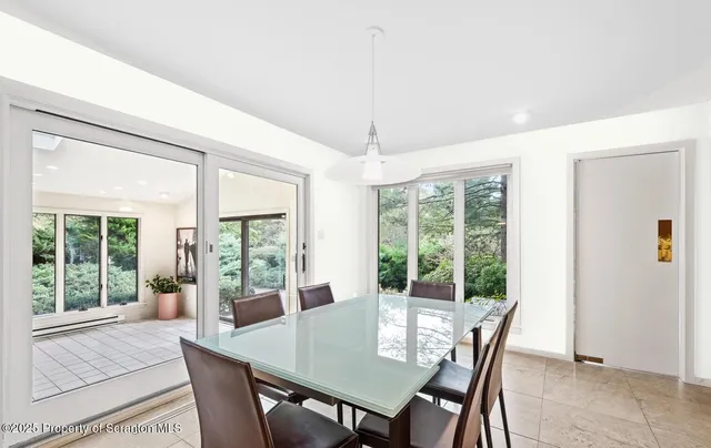 a view of a dining room with furniture large windows and wooden floor