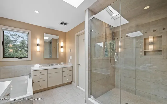 a bathroom with a double vanity sink mirror and shower