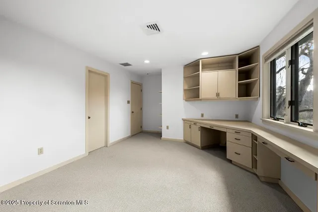 a large white kitchen with stainless steel appliances granite countertop a sink and cabinets with wooden floor
