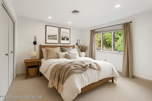 a bedroom with a bed and a large window