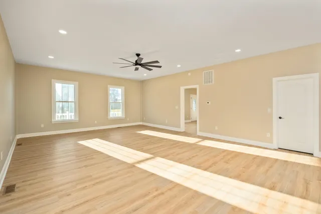 a view of a kitchen with kitchen island a sink wooden floor and appliances