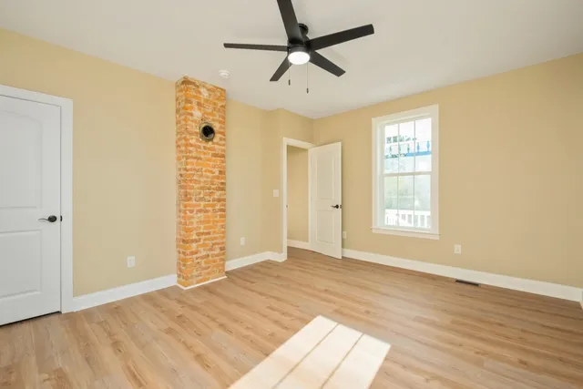 a view of empty room with wooden floor