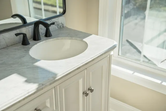 a bathroom with a sink and a mirror with window