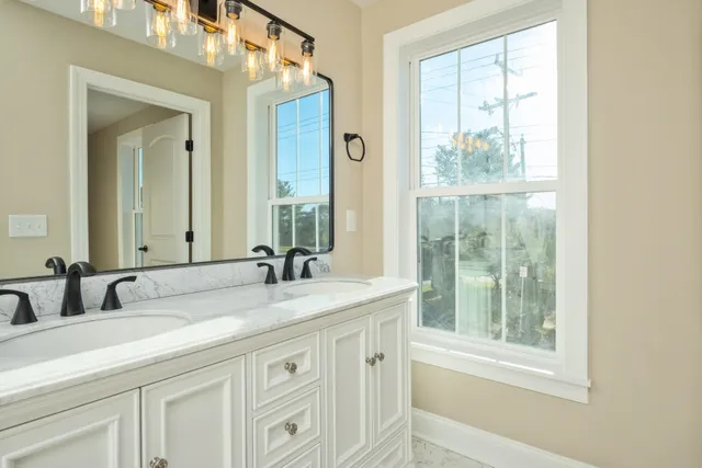 a bathroom with a granite countertop sink a toilet a mirror a vanity and shower