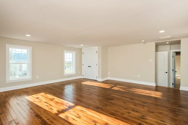 a view of an empty room with wooden floor