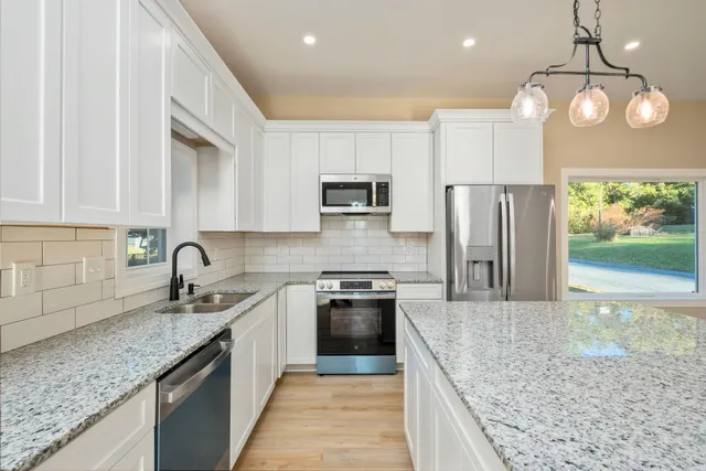 a kitchen with stainless steel appliances granite countertop a sink stove and refrigerator
