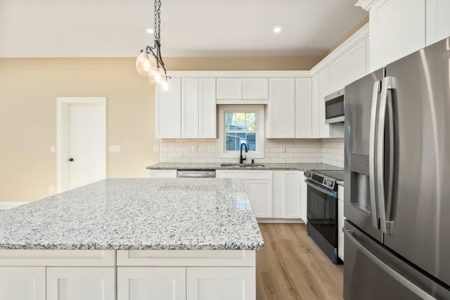 a kitchen with stainless steel appliances granite countertop a sink stove and refrigerator